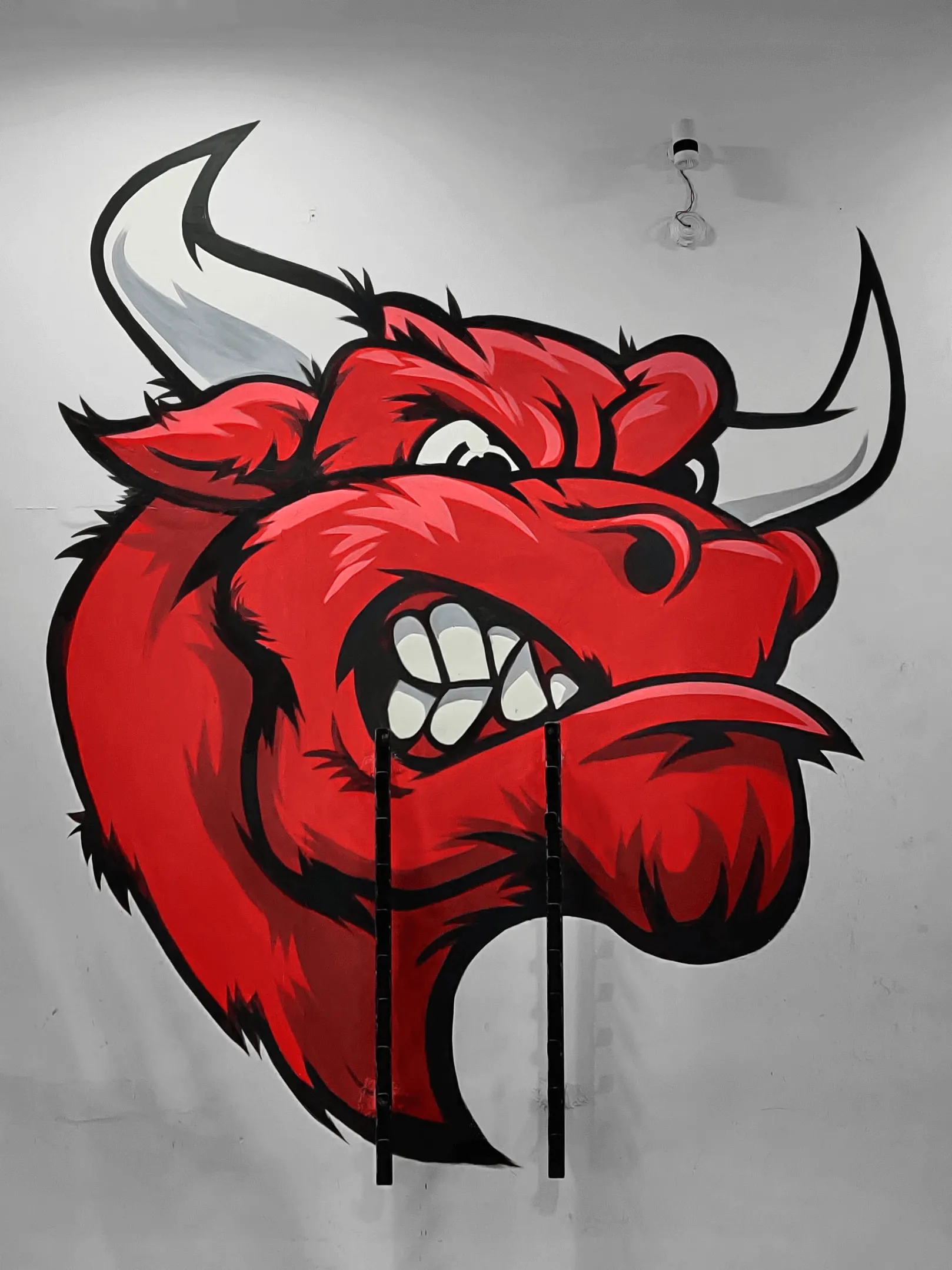 Mural of a red coloured bull head on a white background.